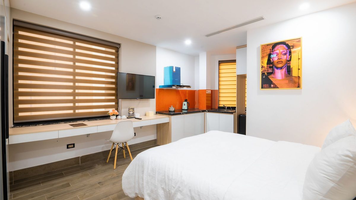 Chambre d'hôtes aux volets de bois, lit fait et fenêtre entrouverte