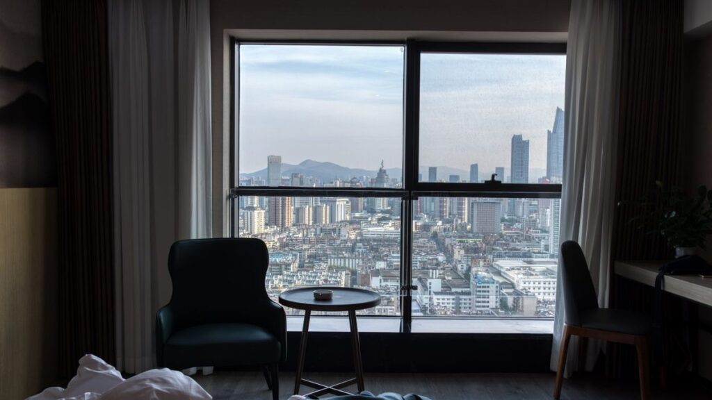 Chambre d'hôtel avec vue sur la ville depuis la fenêtre