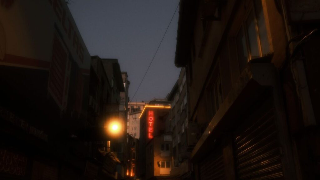 Rue de ville le soir, enseignes d'hôtels allumées
